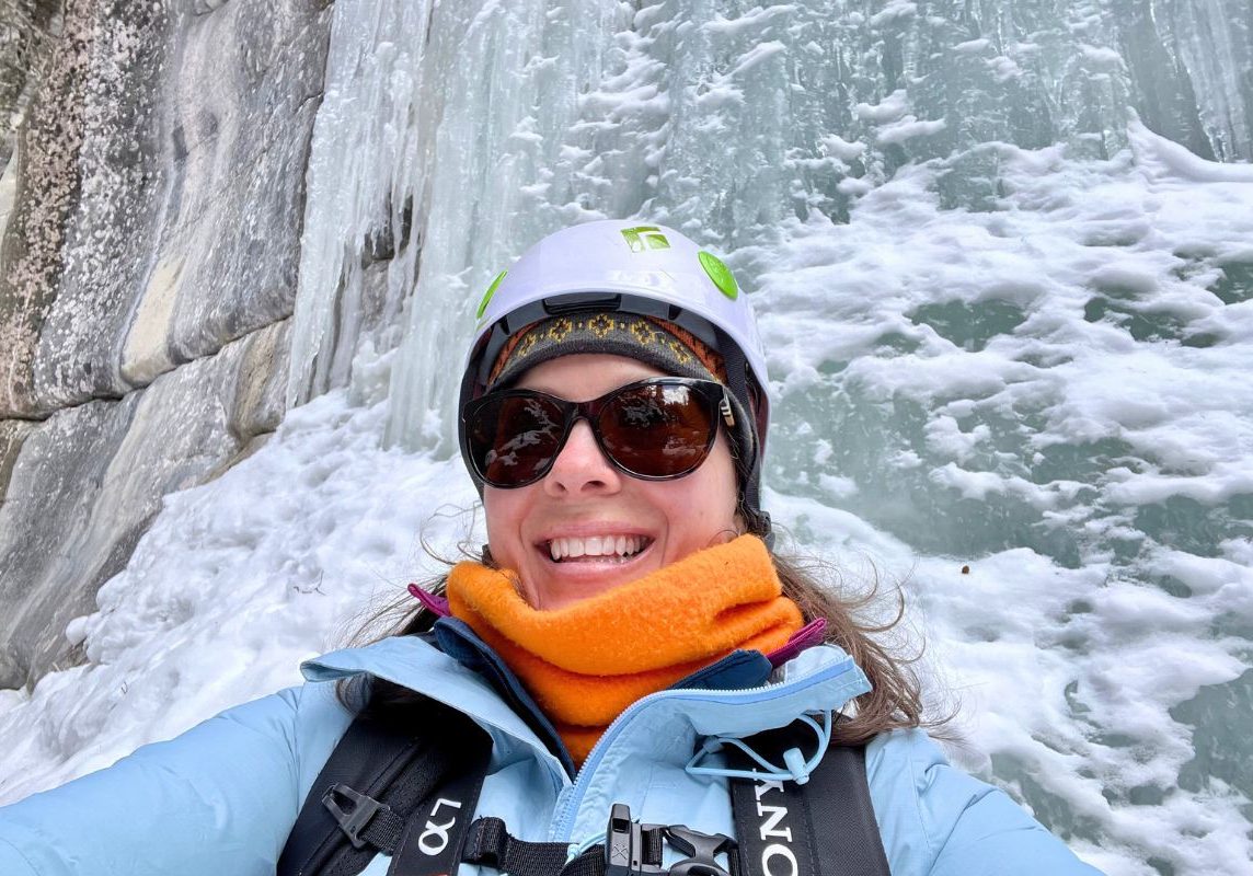 Ashlee standing in front of frozen waterfall.